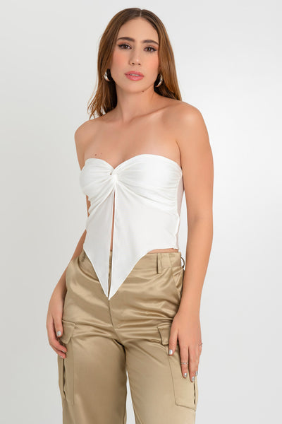 Top strapless satinado de escote corazón con nudo, plisados decorativos en costados y abertura frontal con bajo asimétrico. Rib rizado en borde de bajo.