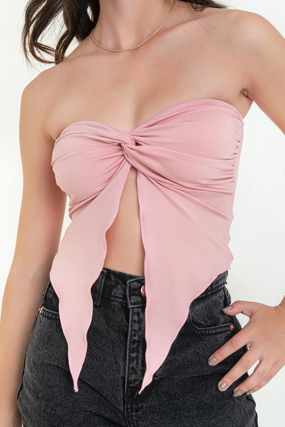 Top strapless de escote corazón con nudo, plisados decorativos en costados y abertura frontal con bajo asimétrico. Rib rizado en borde de bajo.