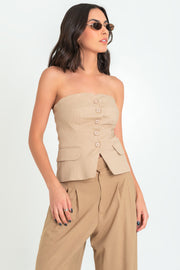 Top tubo de fit ajustado, strapless, escote corazón, bolsillos decorativos frontales con cartera bajo curveado y cierre frontal con hilera de botones. Detalle de fruncido en espalda.