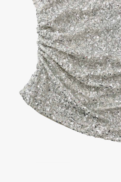 Top tubo de lentejuelas, fit ajustado, escote recto, plisados en costado y bajo diagonal asimétrico.