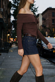 Top corto de punto canalé, fit ajustado, hombros descubiertos, escote recto con doblez en borde, manga larga y cierre frontal con hilera de botones.