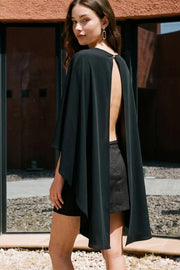 Blusa tipo capa con manga seguida, bajo asimétrico, cuello redondo y escote en espalda. Cierre posterior con botón y ojal.