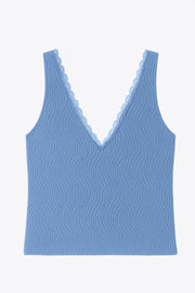 Top de fit ajustado, escote v con encaje en bordes, cortes frontales decorativos con plisados, sin mangas y detalle de textura en tejido.