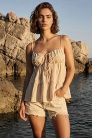 Top de estampado rayas, tirantes delgados ajustables, corte en a, capas con olanes en bajo, escote redondeado con plisados y cut out, abertura frontal y cierre con lazos amarrables. Detalle de fruncido en espalda.