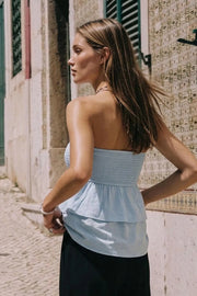 Top strapless de fit ajustado, escote recto con fruncido y peplum con capas de olanes en bajo.