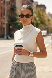Top de fit ajustado, cuello mock con plisados y manga corta seguida.