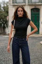 Top de fit ajustado, cuello mock con plisados y manga corta seguida.