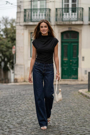 Top de fit ajustado, cuello mock con plisados y manga corta seguida.
