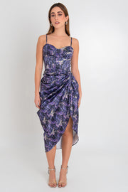 Vestido midi estampado, de tirantes delgados ajustables, escote corazón con cortes y costuras de corset en talle. Bajo asimétrico, cruce frontal con plisados y abertura. Detalle de plisados posteriores decorativos y cierre posterior con cremallera visible en contraste.