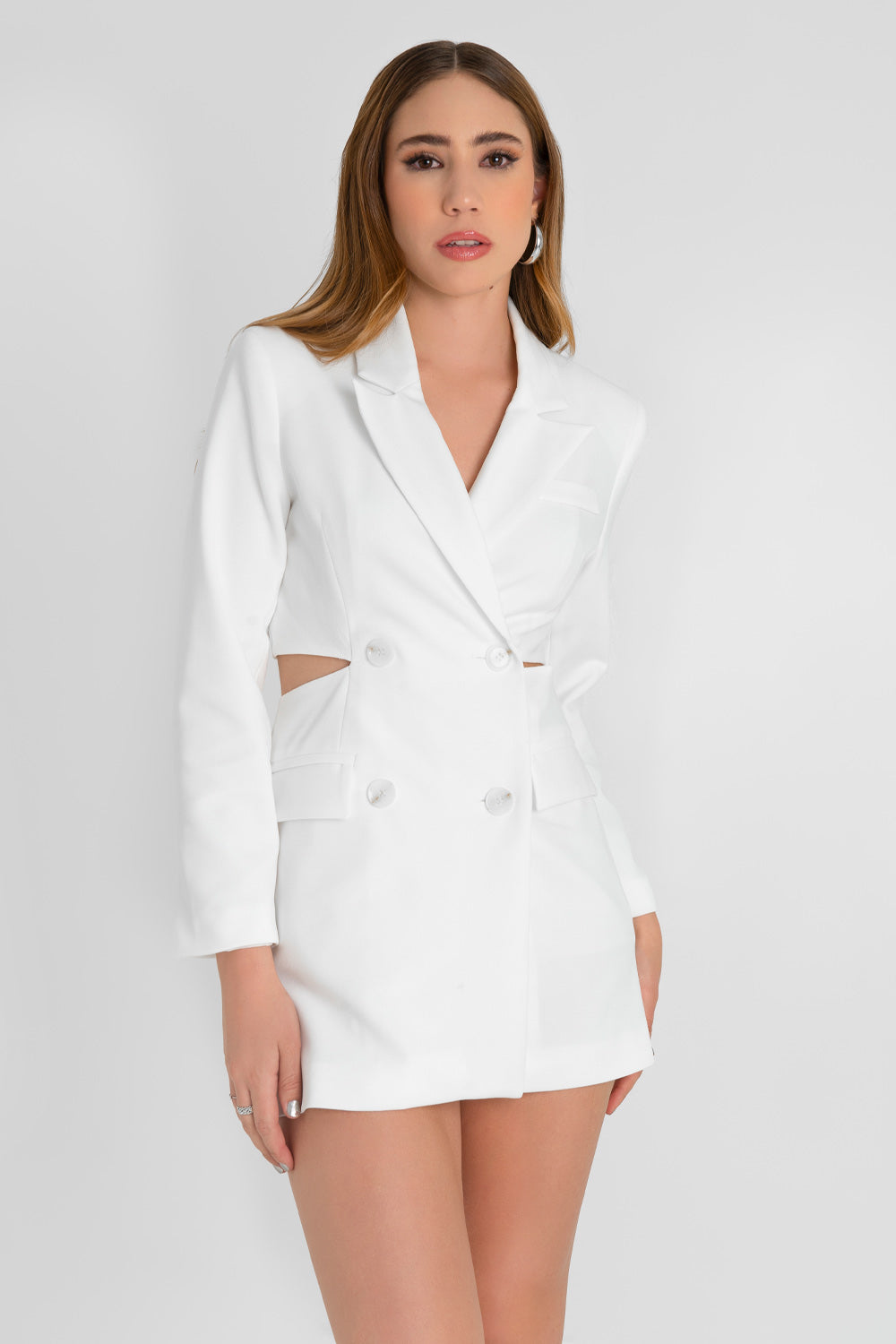 Vestido blazer corto cruzado de fit ajustado, manga larga, con hombreras y solapa. Cruce frontal con doble botón en contraste, bolsillos delanteros con cartera, vivo decorativo frontal y cut out en costados y espalda.