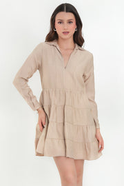 Vestido corto camisero de manga larga con puño abotonado, corte en a, escote v con costuras, cuello camisero y capas con olanes en bajo.