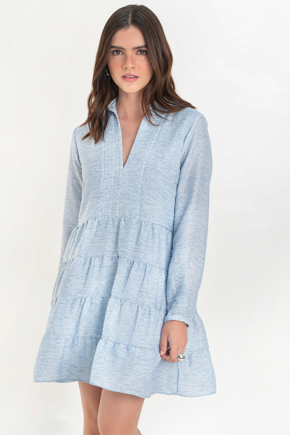 Vestido corto camisero de manga larga con puño abotonado, corte en a, escote v con costuras, cuello camisero y capas con olanes en bajo.