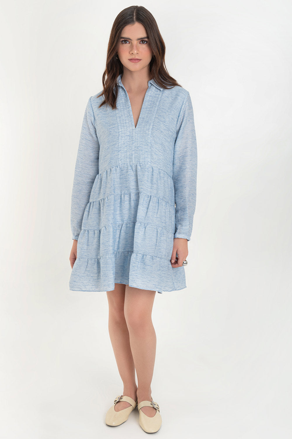 Vestido corto camisero de manga larga con puño abotonado, corte en a, escote v con costuras, cuello camisero y capas con olanes en bajo.