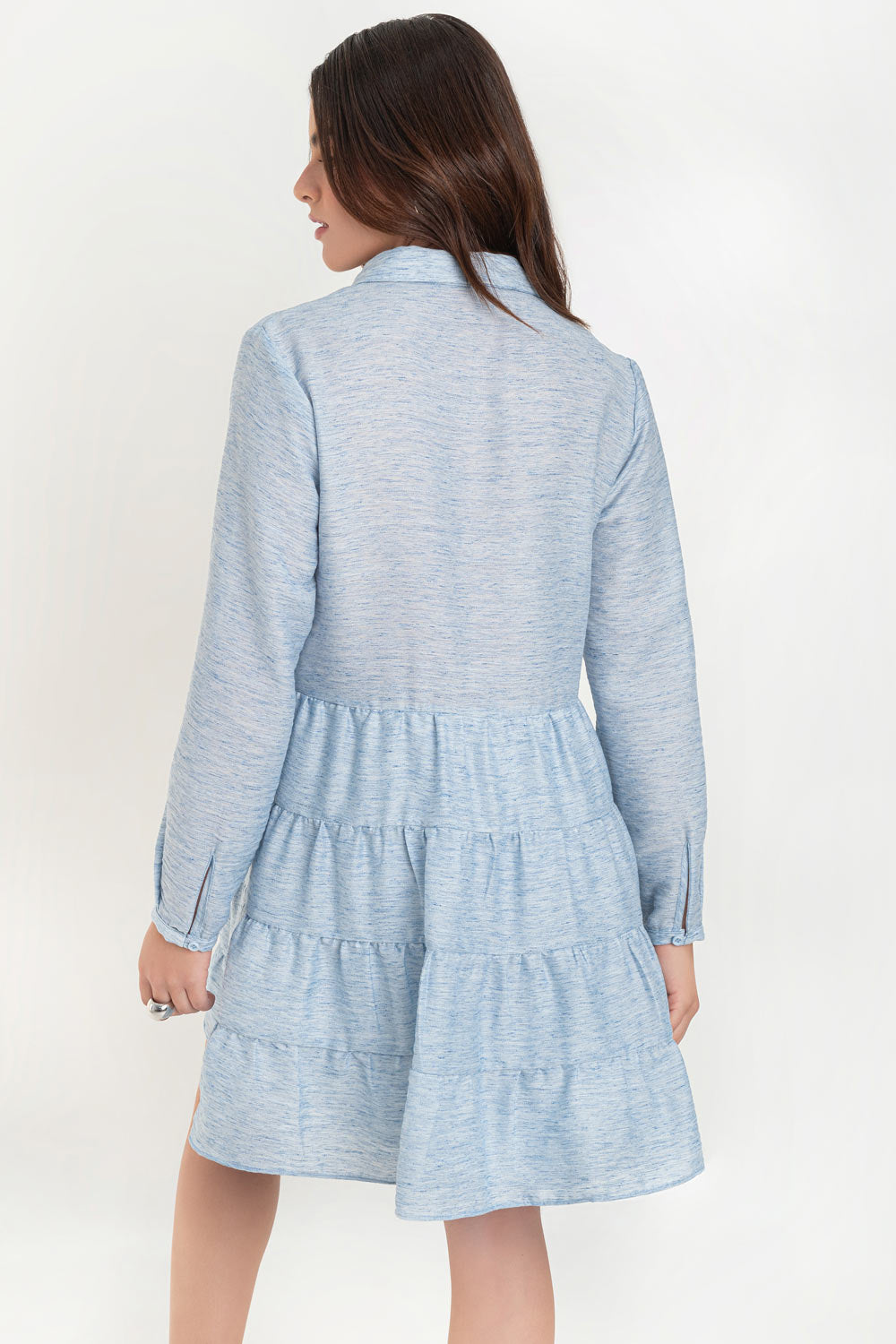 Vestido corto camisero de manga larga con puño abotonado, corte en a, escote v con costuras, cuello camisero y capas con olanes en bajo.
