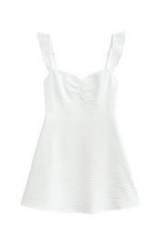 Vestido corto de escote v con plisados frontales, corte en a, tirantes ajustables con olanes en hombros, lazado ajustable en espalda y cierre posterior con cremallera oculta.