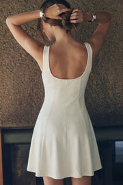 Vestido corto de escote cuadrado, sin mangas, cortes decorativos, escote en espalda y corte en a con olanes en bajo.