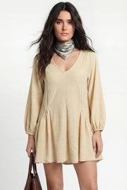 Vestido corto de fit fluido, escote v, manga 3/4 abullonada con rib elástico en puños y plisados decorativos laterales con elástico.