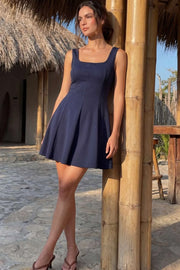 Vestido corto de tirantes, cortes frontales, escote cuadrado y corte en a con olanes en bajo.