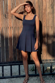 Vestido corto de tirantes, cortes frontales, escote cuadrado y corte en a con olanes en bajo.