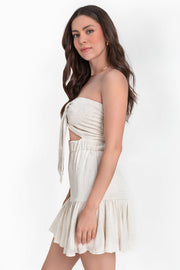 Vestido corto strapless de escote corazón con nudo amarrable decorativo con plisados, cut out frontal, pretina elástica, corte en a con olanes en bajo y fruncido en espalda.