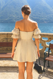 Vestido corto de hombros descubiertos, estampado rayas, escote corazón, manga corta abullonada con rib elástico y olanes en borde, corte en a y cierre posterior con cremallera oculta.