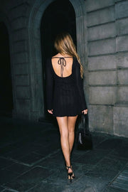 Vestido corto de fit ajustado, manga larga, cuello barco, corte en a y escote en espalda con lazo amarrable posterior. Detalle de textura en tejido.