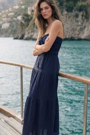 Vestido midi strapless de escote corazón con nudo amarrable, cut out frontal, cintura elástica, detalle de capas de olanes en bajo y fruncido en espalda.
