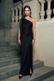 Vestido largo satinado de fit fluido, escote diagonal, asimétrico de un hombro con nudo amarrable y abertura lateral en bajo. Cierre lateral con cremallera oculta.