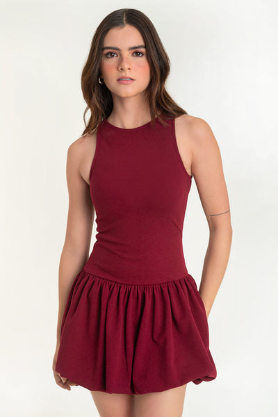 Vestido corto globo, sin mangas, fit ajustado, cuello redondo, bajo con acabado en volumen y plisados en cadera.