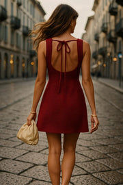 Vestido corto de fit recto, sin mangas, cuello barco y escote en espalda con lazo amarrable posterior.
