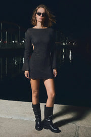 Vestido corto de fit ajustado, manga larga con puño amplio, cuello barco y escote en espalda con doble lazo amarrable posterior. Detalle de textura en tejido.