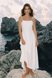 Vestido largo de fit ajustado, corte en a con olanes en bajo, tirantes delgados con nudo amarrable, escote recto y cierre posterior con cremallera oculta.