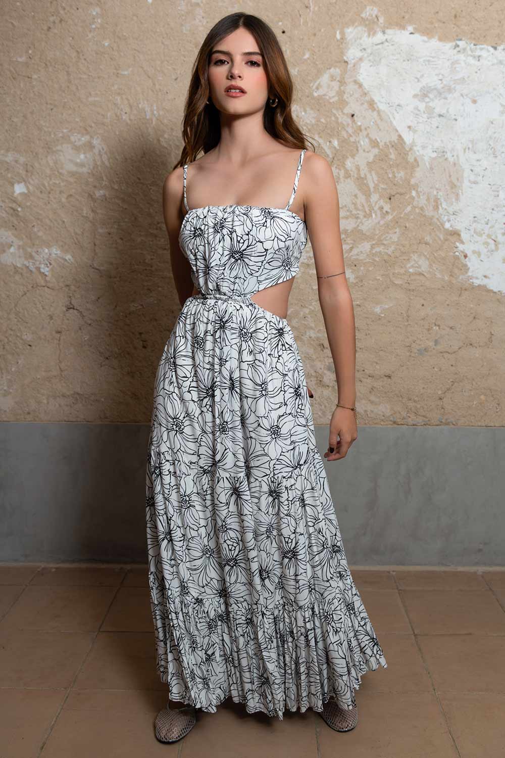 Maxi vestido de estampado floral, escote recto con plisados frontales, tirantes delgados ajustables, cut out en costados y espalda, rib elástico en cintura y detalle de capas de olanes en bajo.