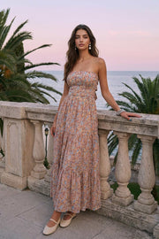 Vestido midi strapless de estampado floral, escote recto, cut out en espalda con nudo amarrable, cintura elástica, detalle de capas de olanes en bajo y fruncido en espalda.