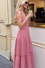 Vestido largo de corte en a, estampado cuadros, tirantes delgados con nudo amarrable, bajo con capas de olanes, cut out en costados y espalda. Detalle de rib elástico en cintura y fruncido en espalda.