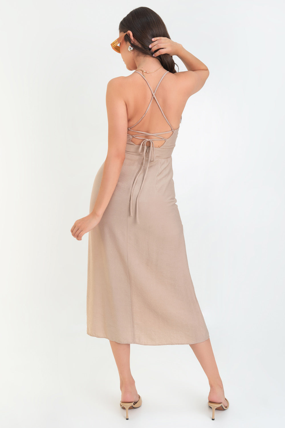 Vestido midi de fit recto, escote curveado con detalles plisados y corte frontal, tirantes delgados con cruce posterior y lazado ajustable en espalda. Abertura frontal en bajo y cierre posterior con cremallera oculta.