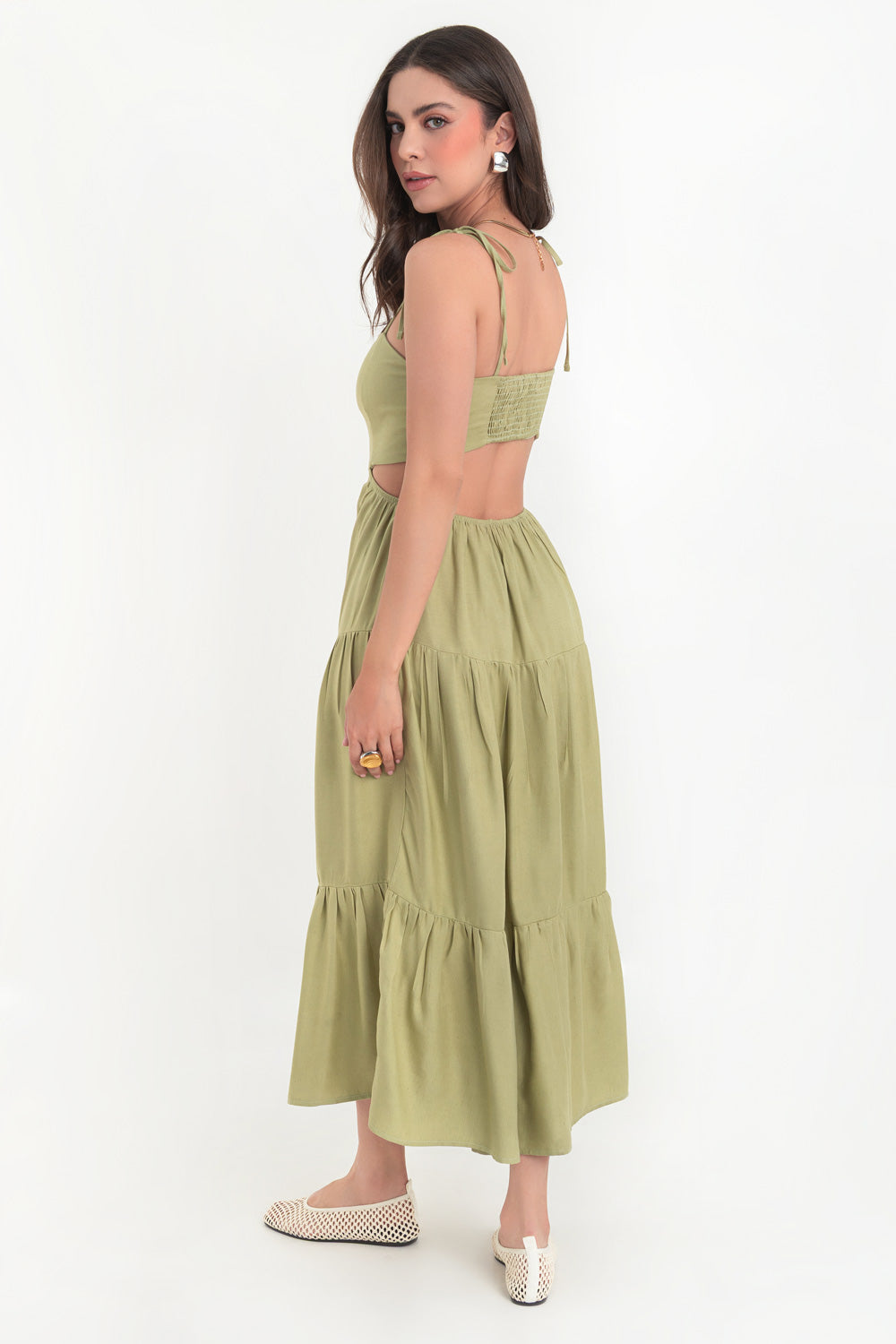 Vestido midi de lino, corte en a, tirantes delgados con nudo amarrable, bajo con capas de olanes, cut out en costados y espalda. Detalle de rib elástico en cintura y fruncido en espalda.