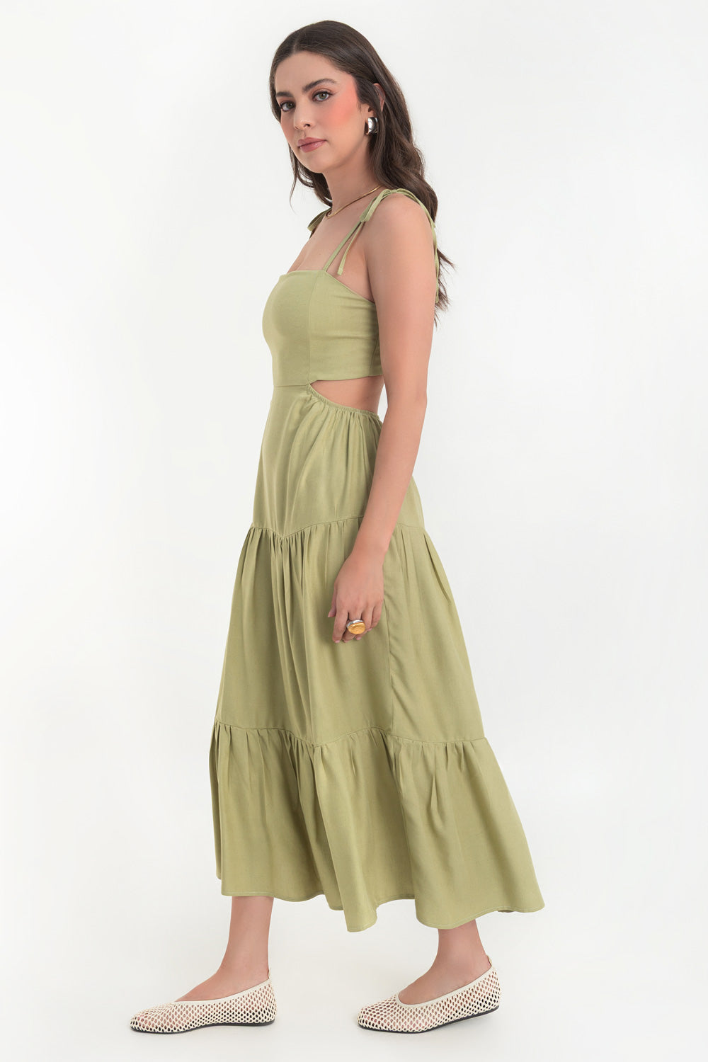 Vestido midi de lino, corte en a, tirantes delgados con nudo amarrable, bajo con capas de olanes, cut out en costados y espalda. Detalle de rib elástico en cintura y fruncido en espalda.