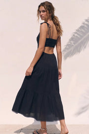 Vestido midi de lino, corte en a, tirantes delgados con nudo amarrable, bajo con capas de olanes, cut out en costados y espalda. Detalle de rib elástico en cintura y fruncido en espalda.