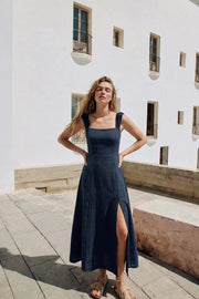 Vestido midi de fit recto, escote recto, corte frontal, tirantes elásticos con plisados y escote en espalda con lazado ajustable. Abertura frontal en bajo, rib elástico y cremallera oculta posterior.