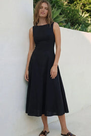 Vestido midi de lino, sin mangas, corte en a, cuello barco, escote en espalda y cortes frontales decorativos. Cierre lateral con cremallera oculta.