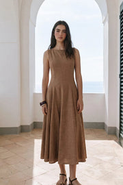 Vestido midi de lino, sin mangas, corte en a, cuello barco, escote en espalda y cortes frontales decorativos. Cierre lateral con cremallera oculta.