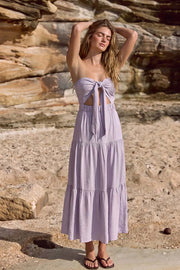 Vestido midi strapless de escote corazón con nudo amarrable, cut out frontal, cintura elástica, detalle de capas de olanes en bajo y fruncido en espalda.