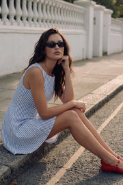 Vestido corto de estampado rayas, sin mangas, corte en a, cuello barco y escote en espalda.
