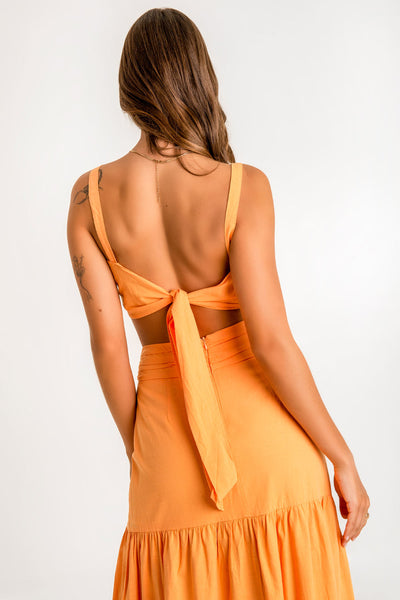 Crop top de lino, fit ajustado, tirantes, escote corazón con detalles plisados y argolla decorativa frontal. Cierre posterior con lazo amarrable.