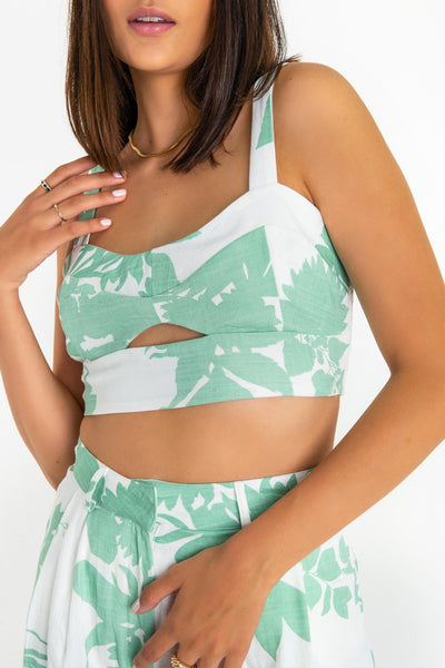 Crop top de estampado tropical, fit ajustado, escote redondo, cortes decorativos frontales con cut out, tirantes y fit ajustado. Detalle de fruncido en espalda.