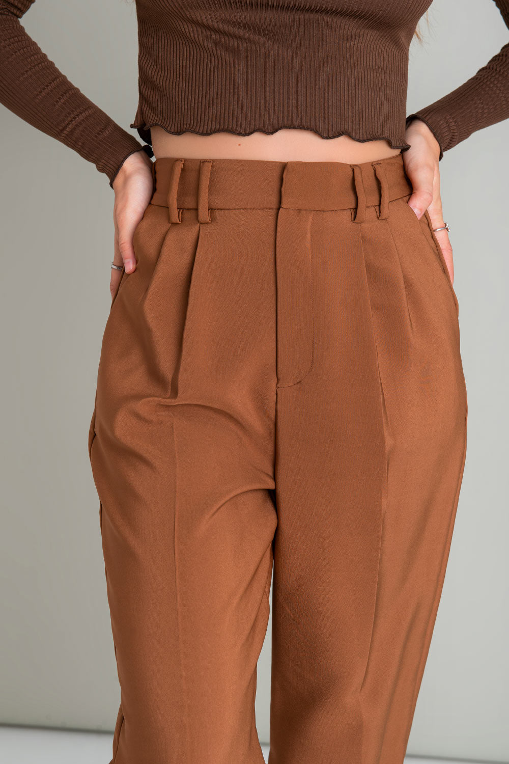 Pantalón wide leg de cintura alta con pretina elástica posterior, trabillas, pinzas frontales, detalle de raya, bolsillos delanteros y vivos posteriores con botón en contraste. Cierre frontal con broche y cremallera oculta.